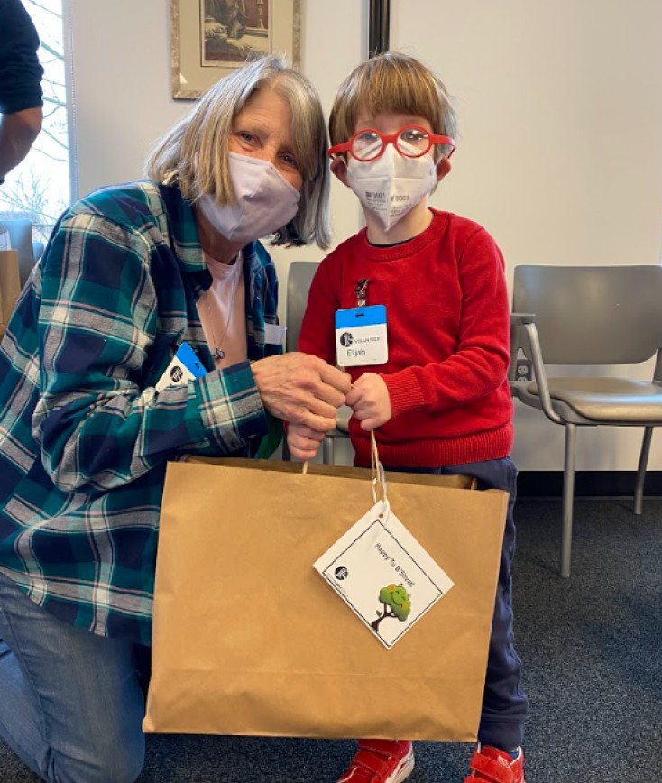 Grandmother and grandson holding a large brown paper bag with handles
