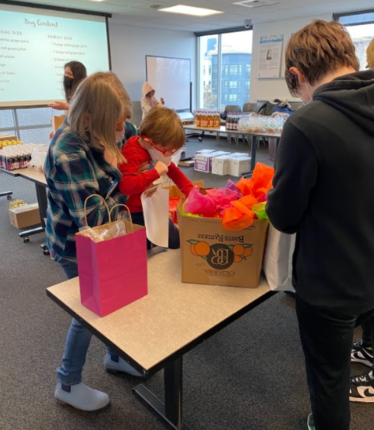 Grandmother picking up grandson to pick something out from a box