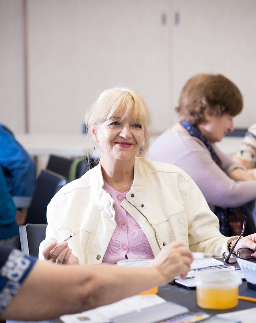 Older woman smiling in an art class