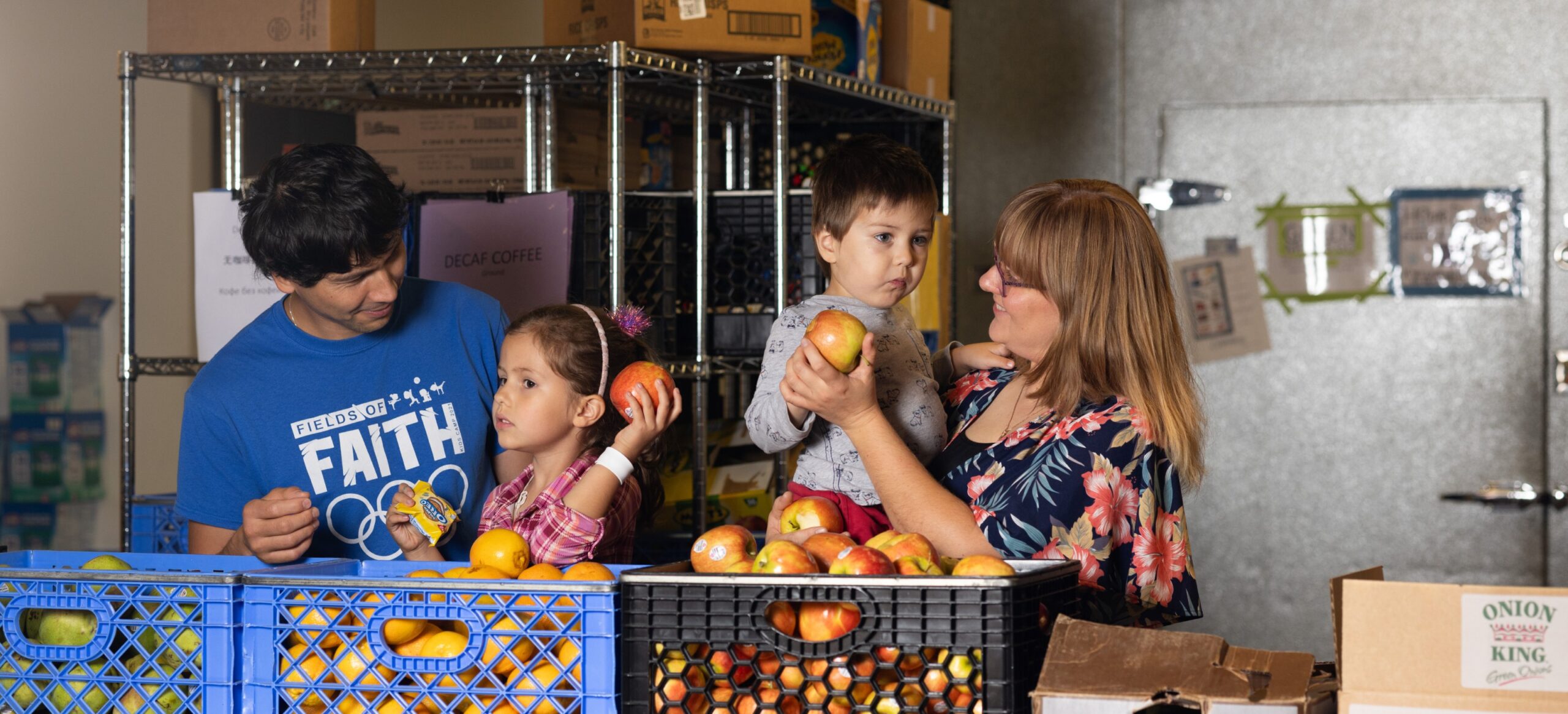 Mother and father holding their son and daughter at the Polack Food bank