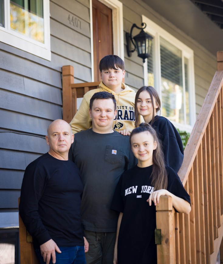 Family of 5 taking a photo on the steps of their home