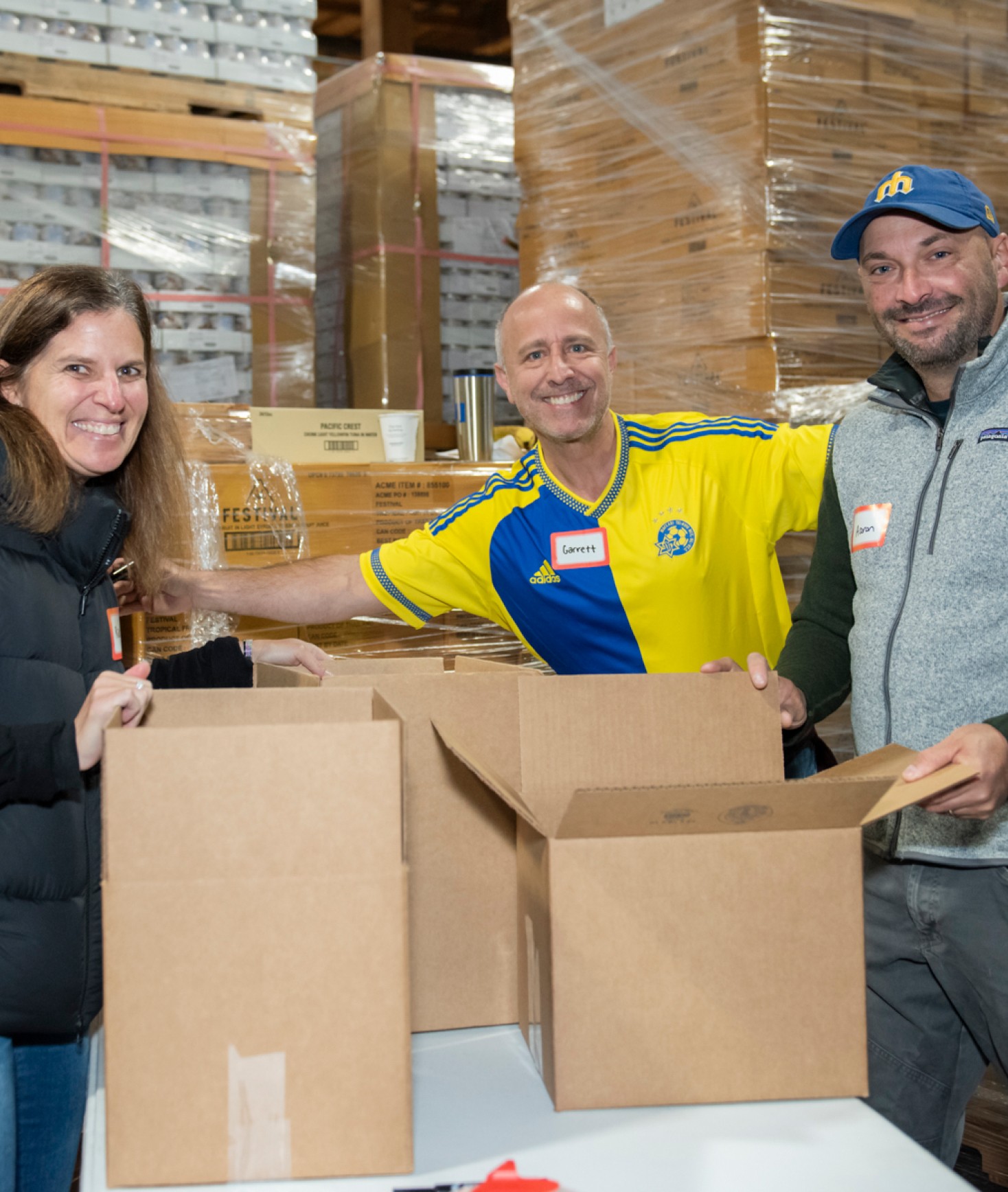 Group of volunteers smiling for a photo as they sort food