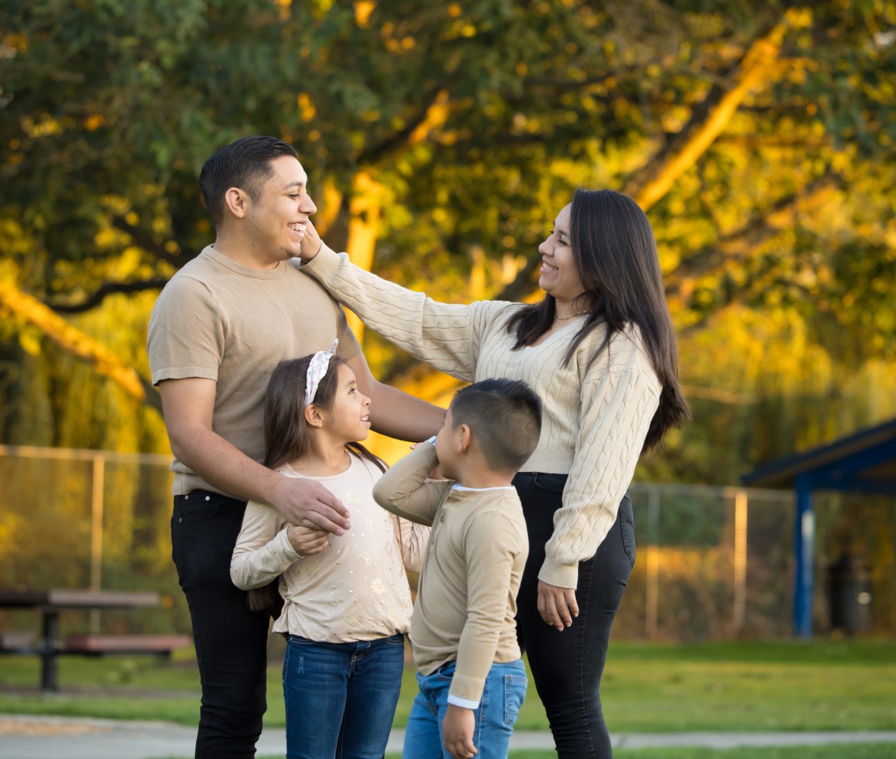 Family of four with two young children looking at each other