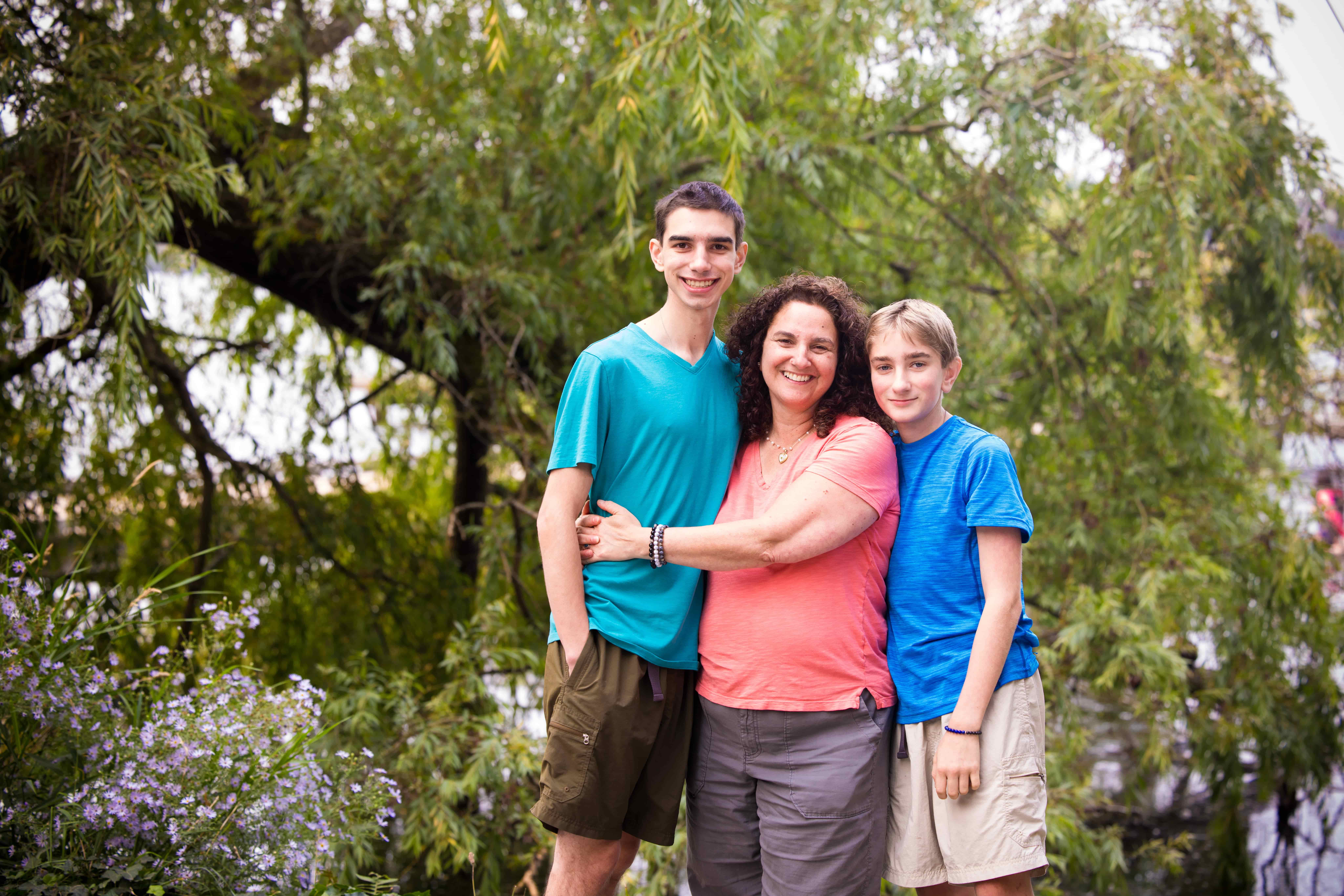 Mom hugging her two sons outside