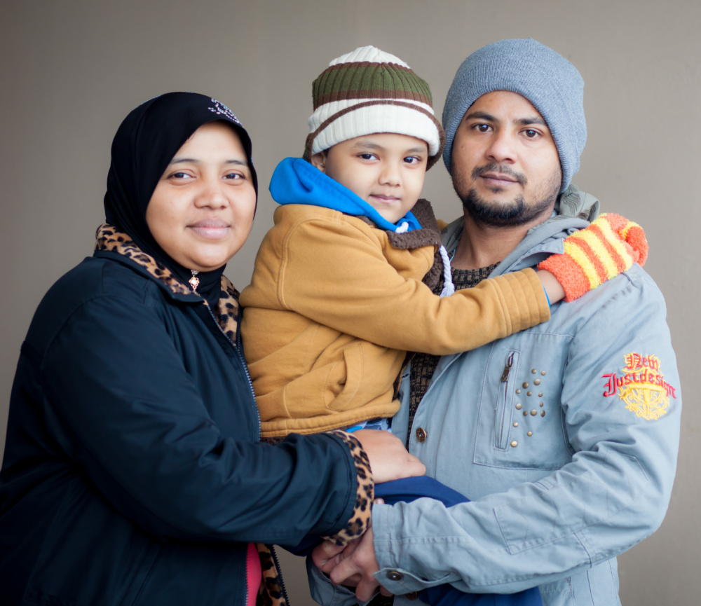 Refugee family in coats and hats