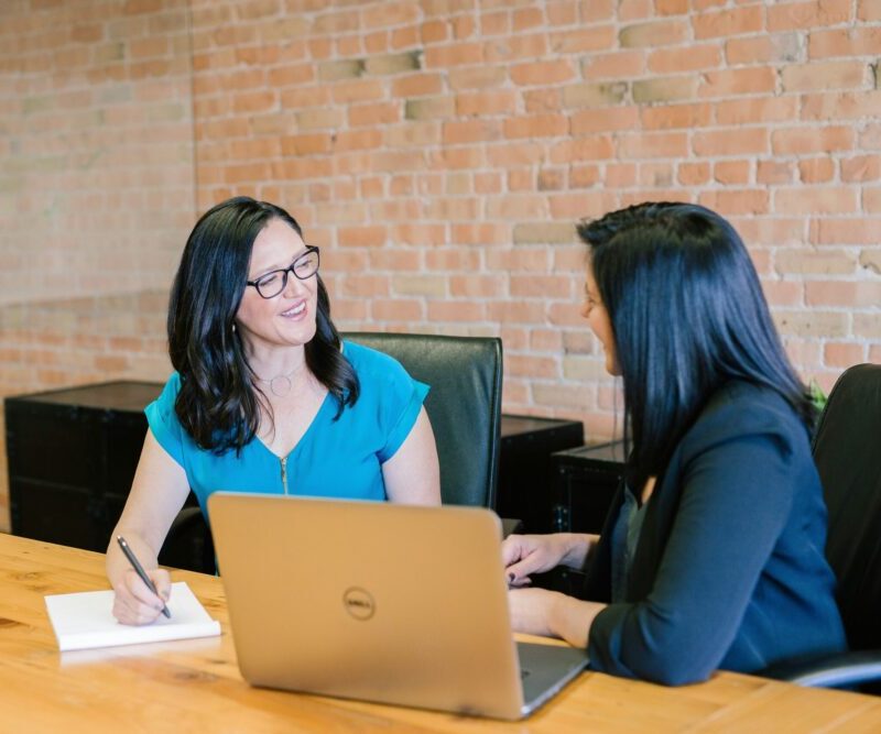 two women talking at a conference table
