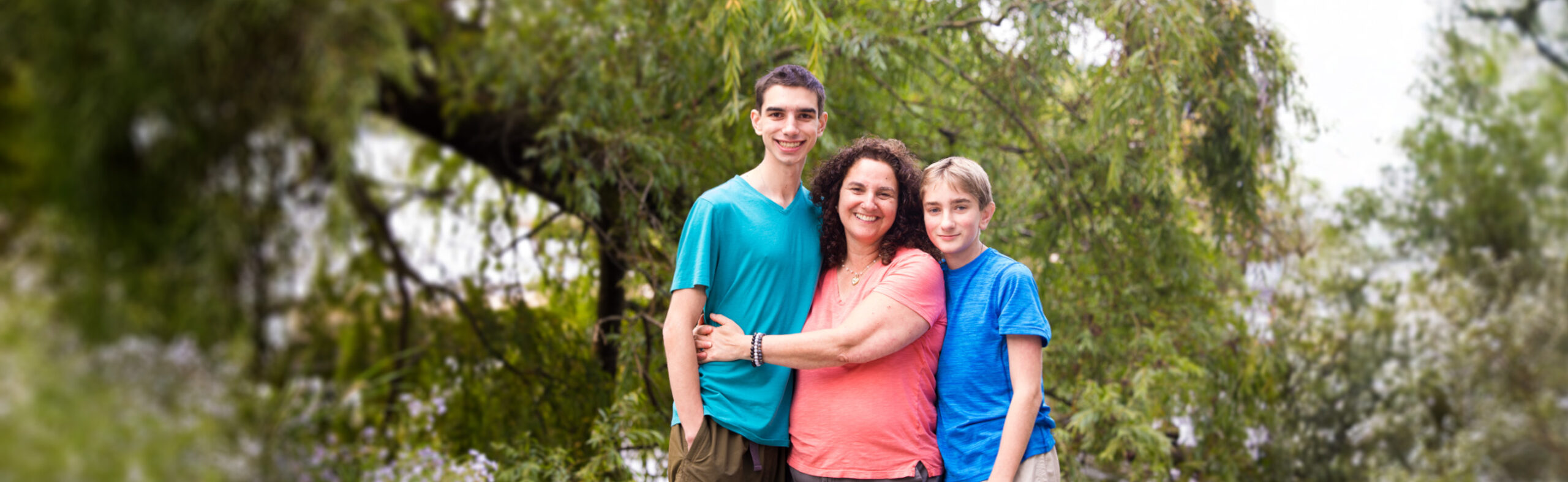 Mom hugging her two sons outside